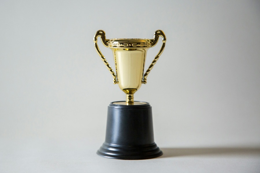 A gold trophy on a black pedestal